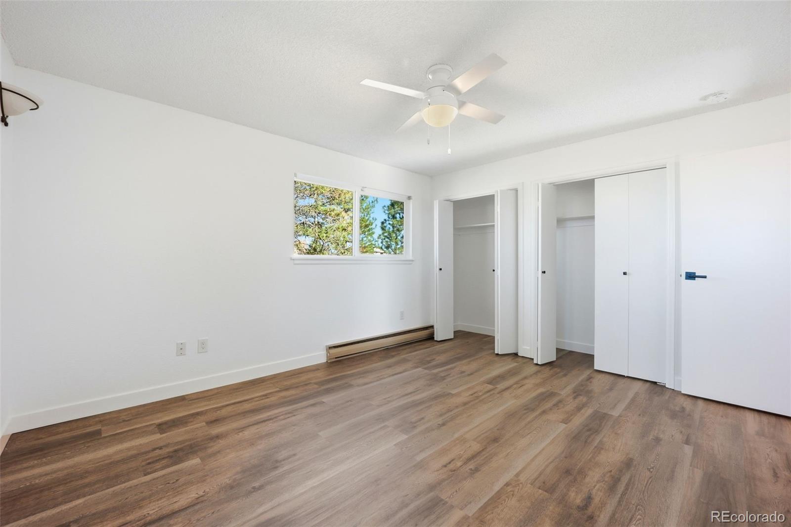 9212 East Tanglewood Road Franktown, CO 80116 - Photo 32 of 50 an empty room with wooden floor and windows