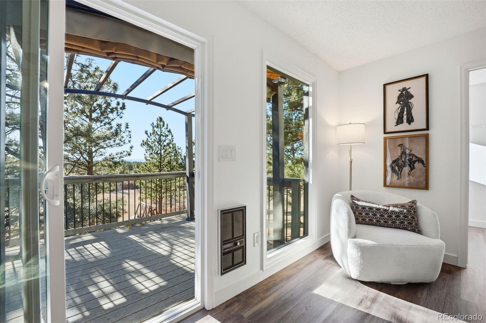 9212 East Tanglewood Road Franktown, CO 80116 - Photo 38 of 50 a living room with furniture and a floor to ceiling window