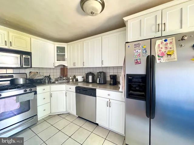 a kitchen with stainless steel appliances granite countertop a refrigerator sink stove and cabinets