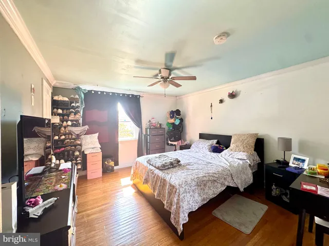 a bedroom with bed and wooden floor