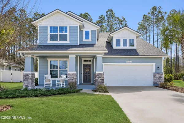 a front view of a house with a garden and plants