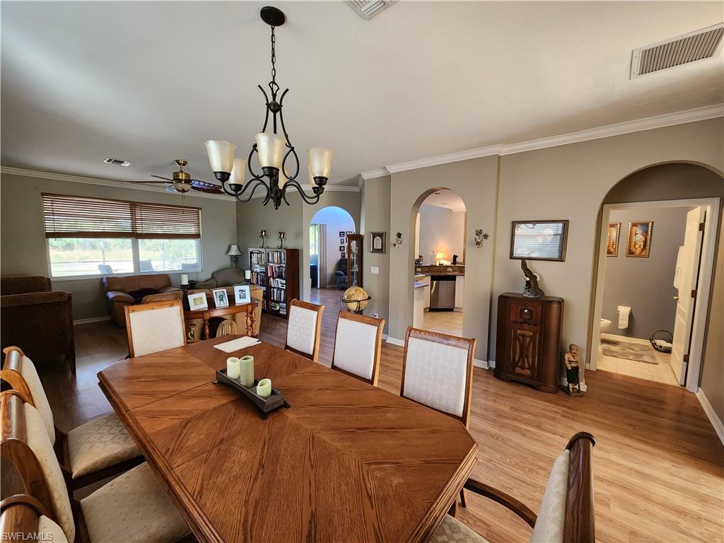 21524 Windham Run Estero, FL 33928 - Photo 4 of 18 a view of a dining room and livingroom with furniture wooden floor a chandelier