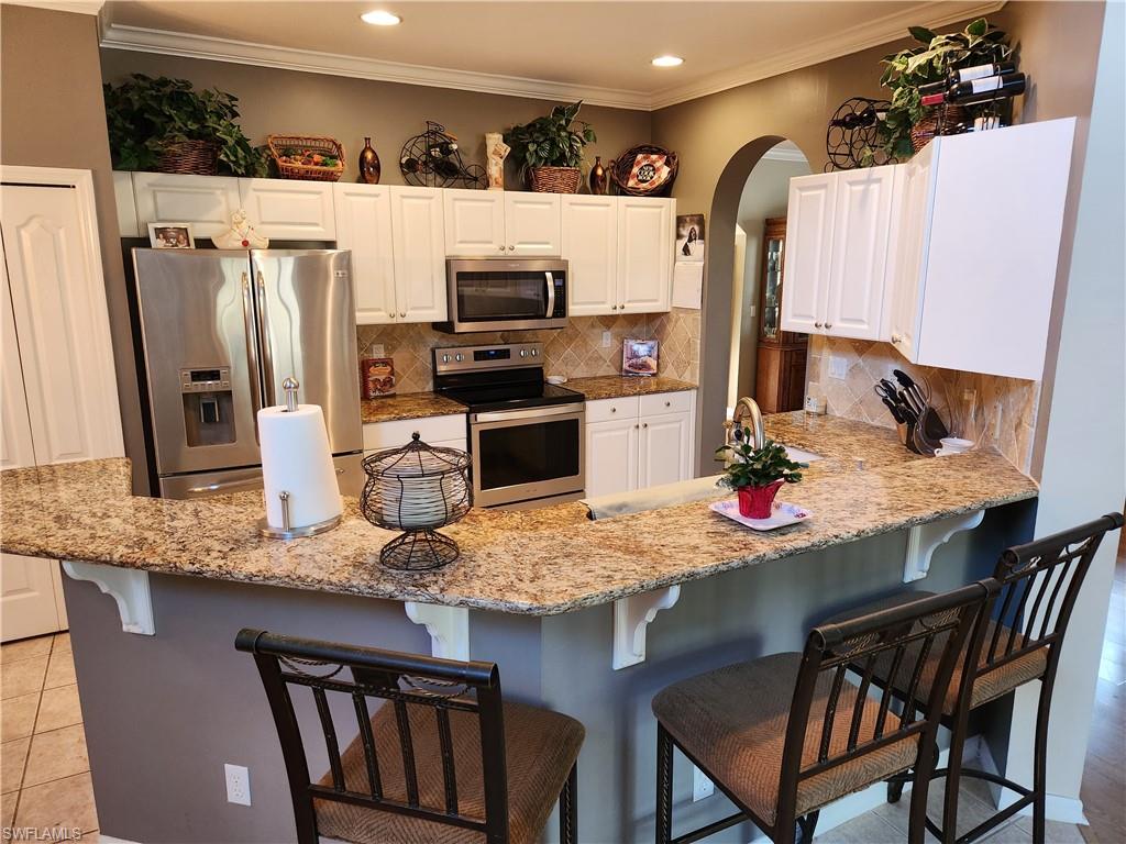 21524 Windham Run Estero, FL 33928 - Photo 5 of 18 a kitchen with stainless steel appliances granite countertop a sink refrigerator and microwave