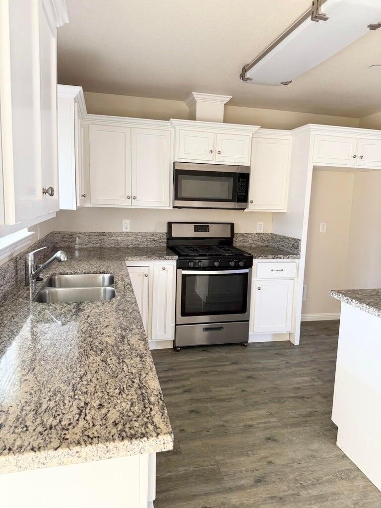 1310 North Belmont Road Exeter, CA 93221 - Photo 4 of 15 a kitchen with stainless steel appliances granite countertop a stove a sink and a microwave
