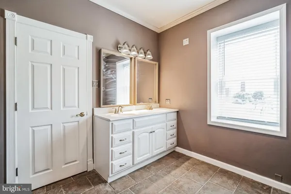 a bathroom with a double vanity sink a mirror and a bathtub