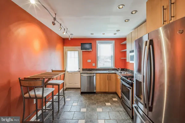 a kitchen with stainless steel appliances granite countertop a refrigerator and a stove