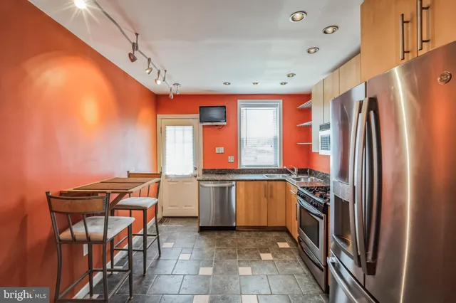 a kitchen with stainless steel appliances granite countertop a refrigerator and a stove