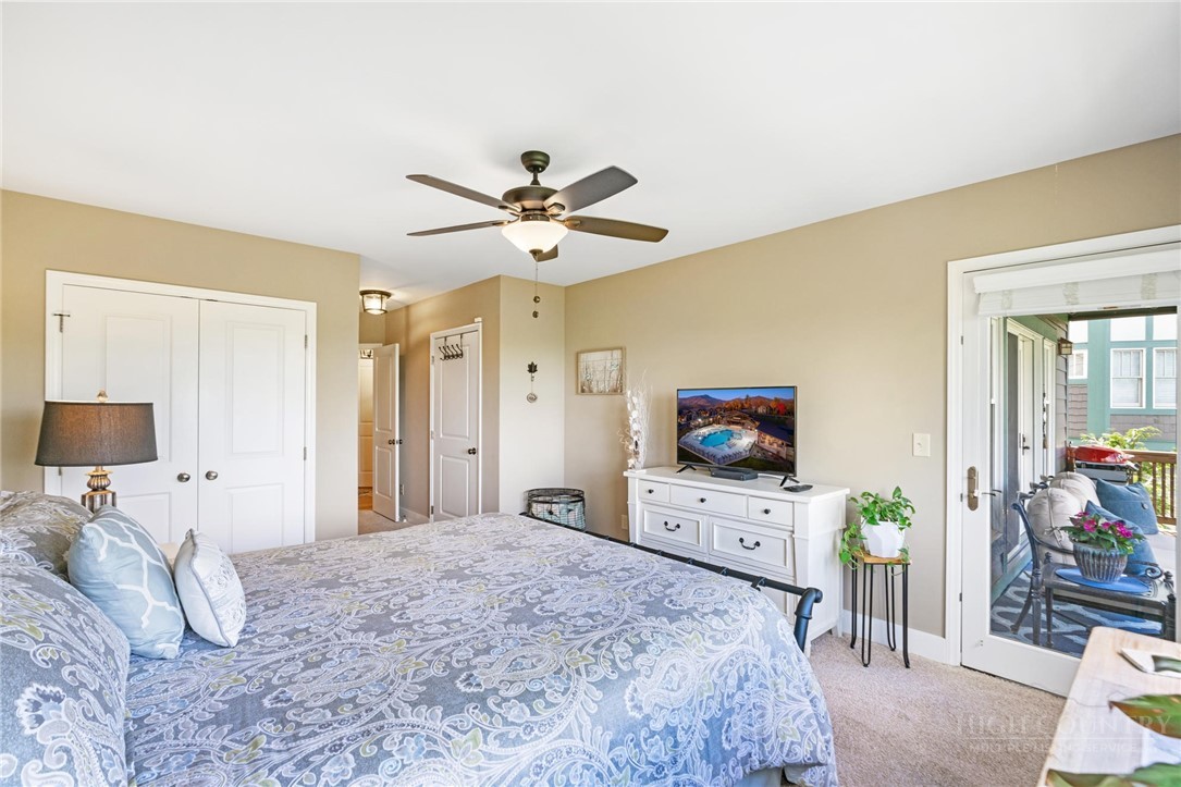 942 Ridge Haven Parkway, Unit R1211 Banner Elk, NC 28604 - Photo 24 of 45 a bedroom with a bed a chandelier and a flat screen tv