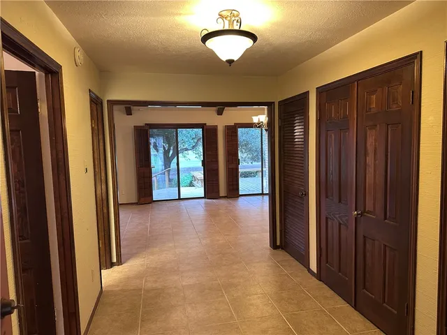 a view of a hallway with furniture and a window
