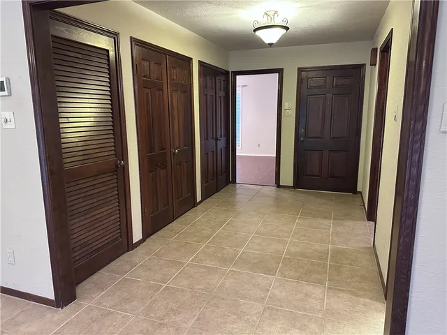 an empty room with closet and a chandelier fan