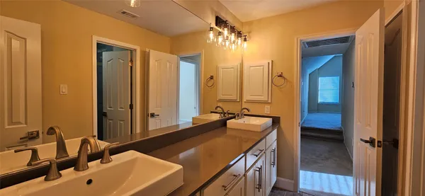 a en suite bathroom with a sink and a large mirror