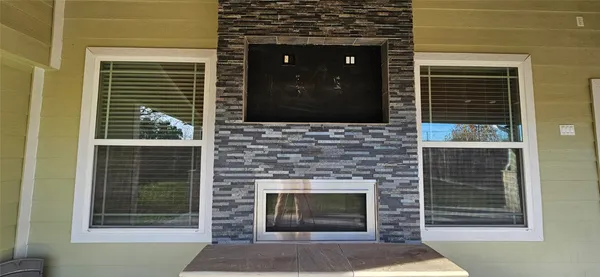 a living room with a fireplace and windows