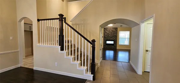 a view of a hallway with wooden floor and stairs
