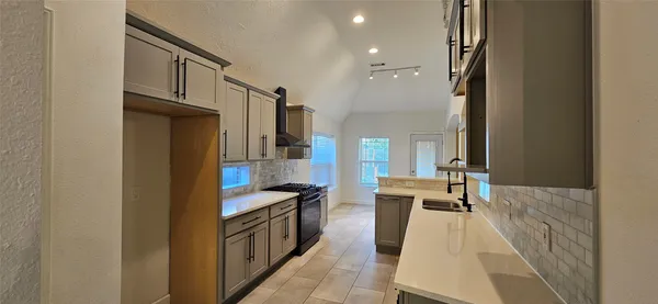 a kitchen with stainless steel appliances granite countertop a refrigerator and a stove top oven