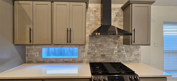 a kitchen with granite countertop a stove and cabinets