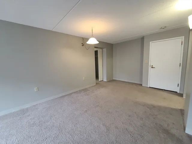 a view of a room with a ceiling fan window and a chandelier