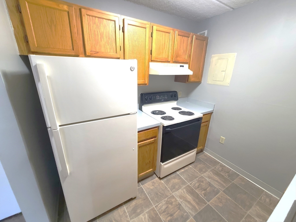 1 South Point Drive, Unit 404 Boston, MA 02125 - Photo 4 of 15 a white refrigerator freezer and a stove