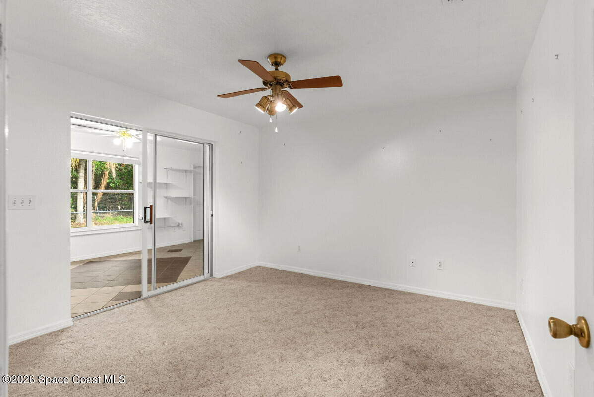 2493 Adamson Road Cocoa, FL 32926 - Photo 35 of 46 an empty room with windows and ceiling fan