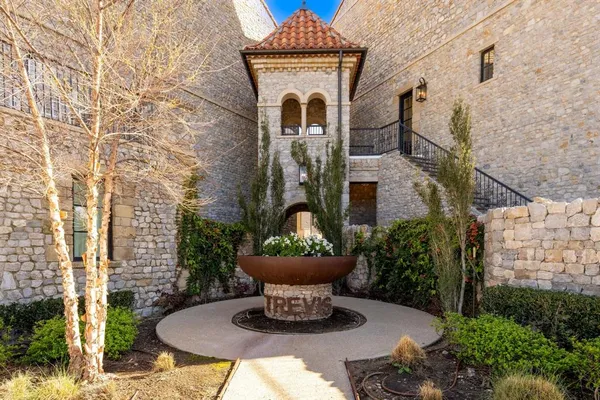 a front view of a house with a fountain