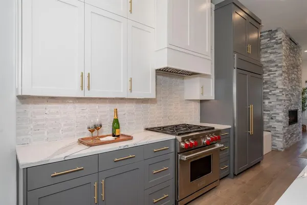 a kitchen with stainless steel appliances granite countertop a sink and a stove next to a window