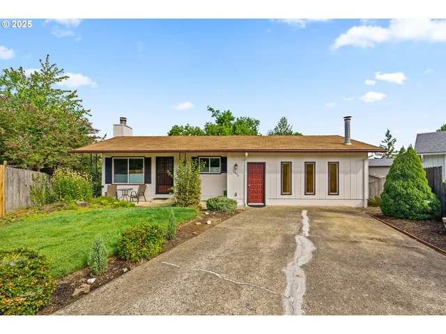 a front view of a house with a garden and yard