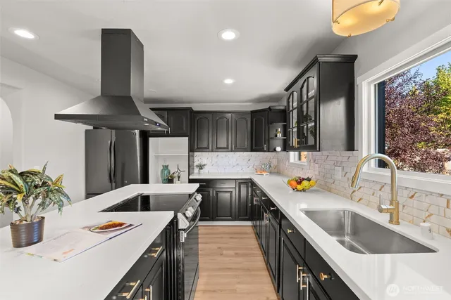 a kitchen that has a sink and a stove with wooden floor