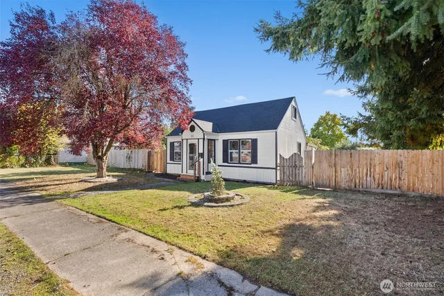 a view of a house with backyard and tree