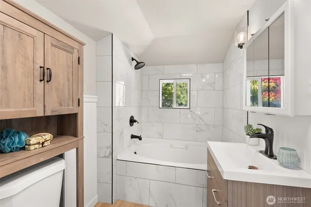 a bathroom with a tub sink and mirror