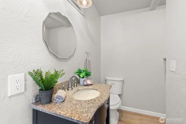 a bathroom with a granite countertop sink and a mirror