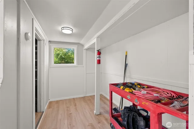 a view of a hallway with workspace and wooden floor