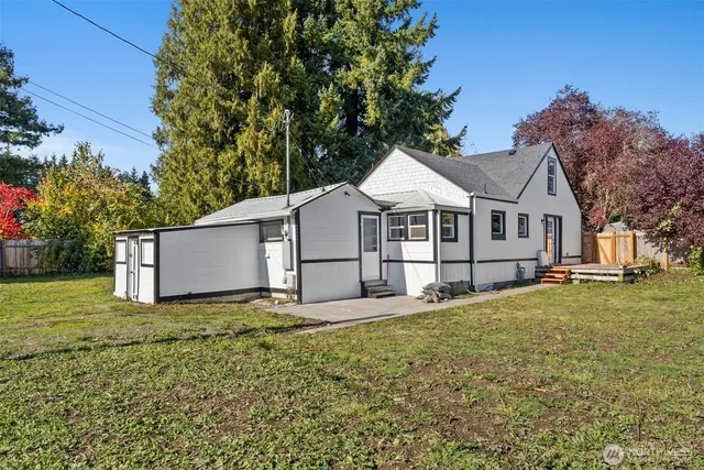 a white house that has a tree in front of it