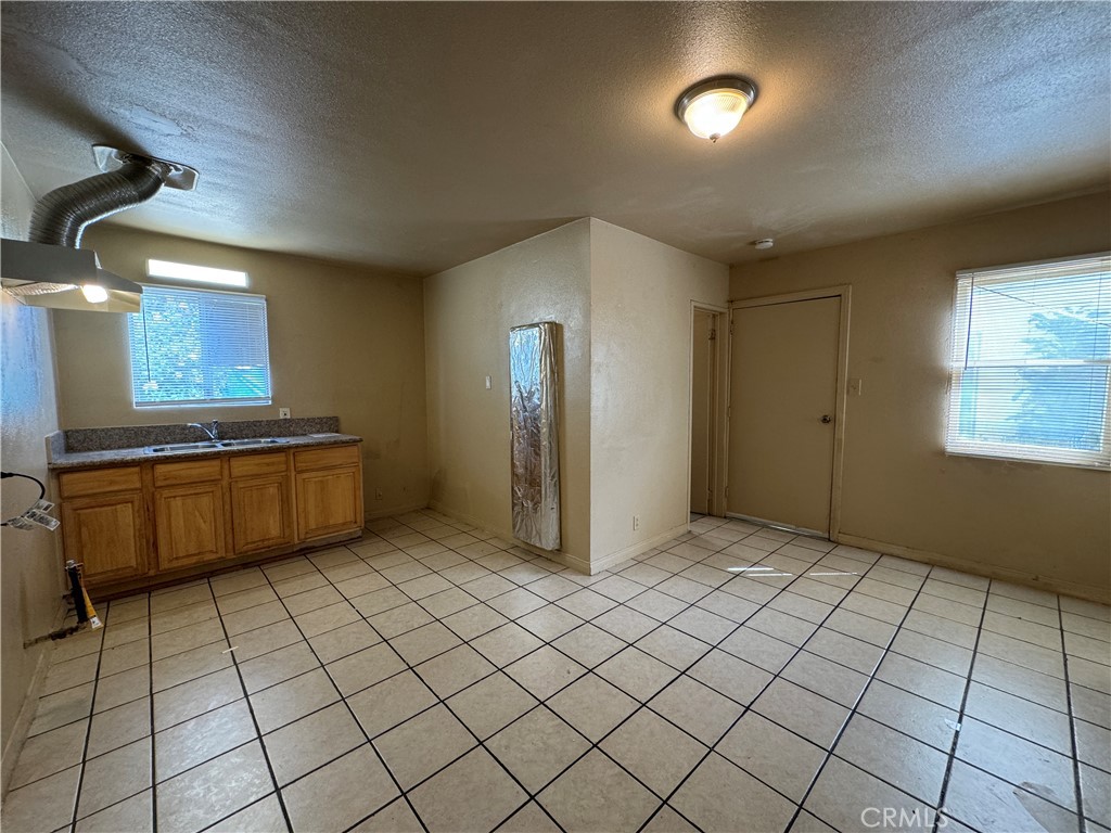 a view of a kitchen with kitchen island granite countertop a sink a counter top space and cabinets