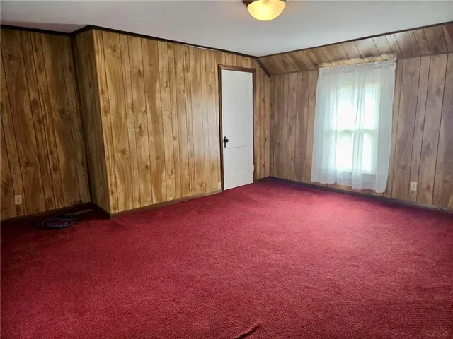 an empty room with windows & curtain