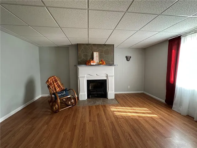 a view of empty room with wooden floor and fireplace