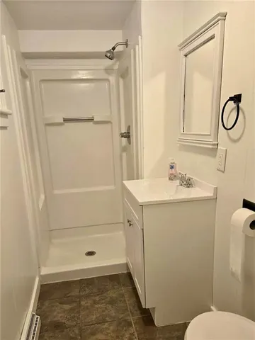 a bathroom with a sink a toilet a shower and a mirror