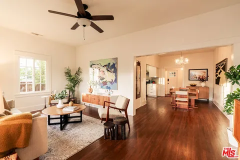 a view of a dining room with furniture a chandelier and wooden floor