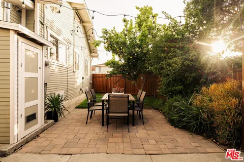 a view of a patio with table and chairs and potted plants