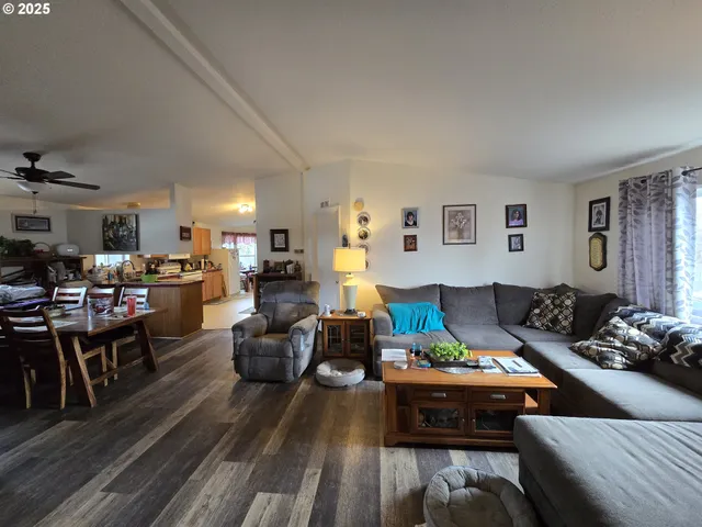 a living room with furniture kitchen view and a window