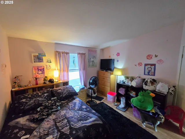 a living room with furniture a flat screen tv and a window
