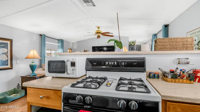 a kitchen with stainless steel appliances kitchen island granite countertop a table chairs in it and wooden floor