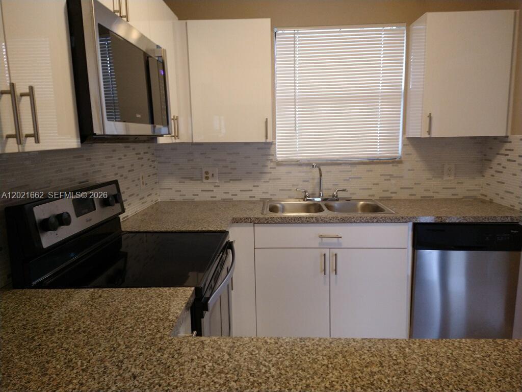 3263 Kirk Road, Unit 2 Lake Worth, FL 33461 - Photo 8 of 14 a kitchen with a sink a stove and cabinets