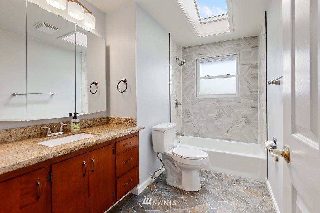 1015 Jones Avenue South Renton, WA 98057 - Photo 26 of 40 a bathroom with a granite countertop toilet a sink and bathtub