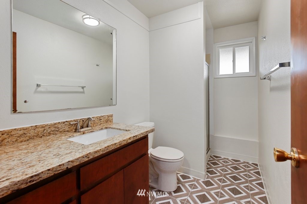 1015 Jones Avenue South Renton, WA 98057 - Photo 30 of 40 a bathroom with a granite countertop sink toilet and shower