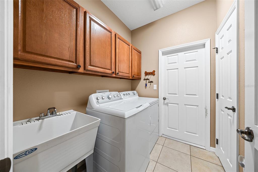 8713 Southwest 83rd Court Road Ocala, FL 34481 - Photo 17 of 23 a utility room with a sink a washer and dryer