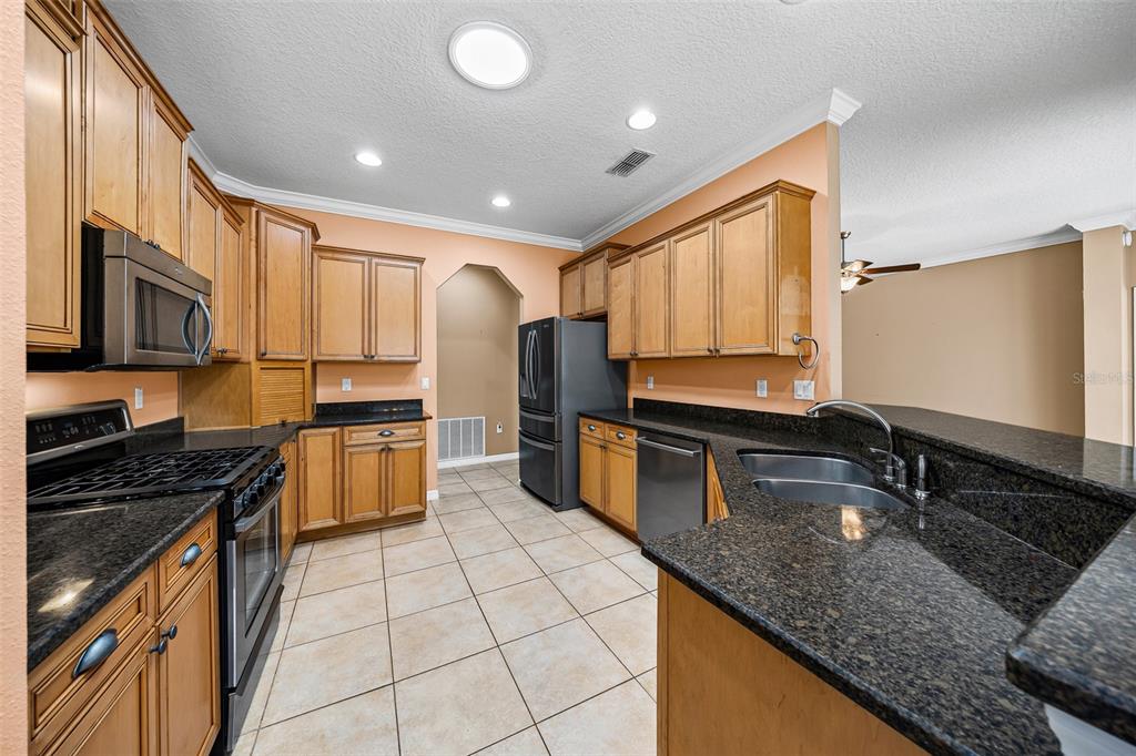 8713 Southwest 83rd Court Road Ocala, FL 34481 - Photo 8 of 23 a kitchen with stainless steel appliances granite countertop a sink stove and microwave