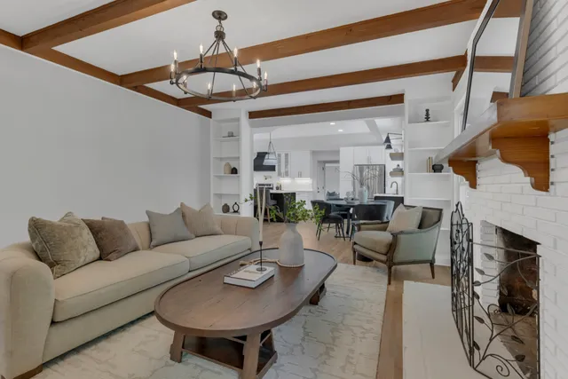 a living room with furniture a fireplace and a chandelier