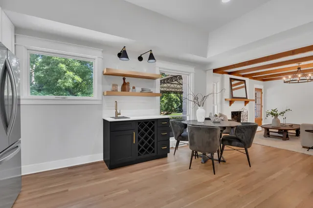 a living room with furniture a large window and wooden floor