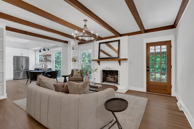 a living room with furniture a fireplace and a floor to ceiling window