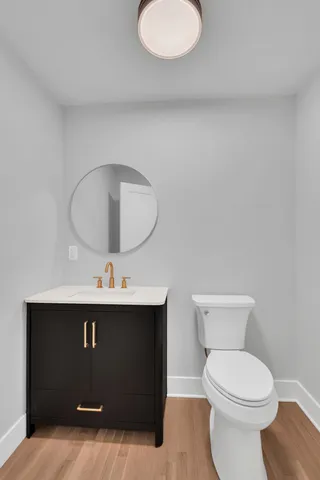 a bathroom with a sink mirror vanity and toilet