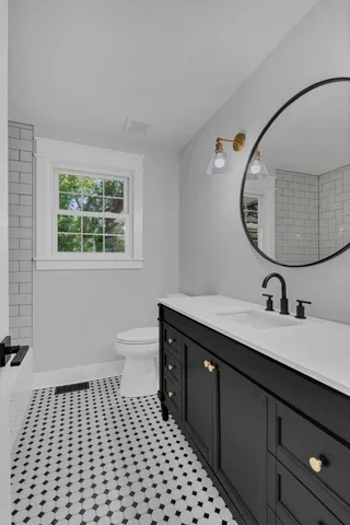 a bathroom with a sink a toilet and a mirror